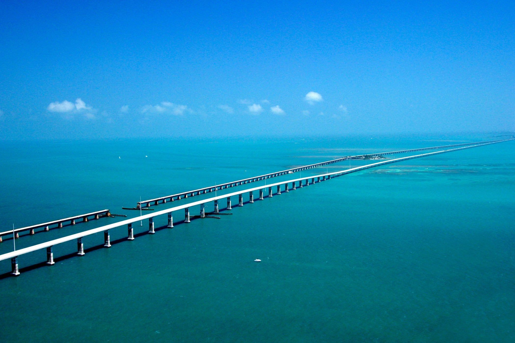 Aerial view of the Seven Mile Bridge and the old Flagler railroad bridge running across turquoise water in the Florida Keys
